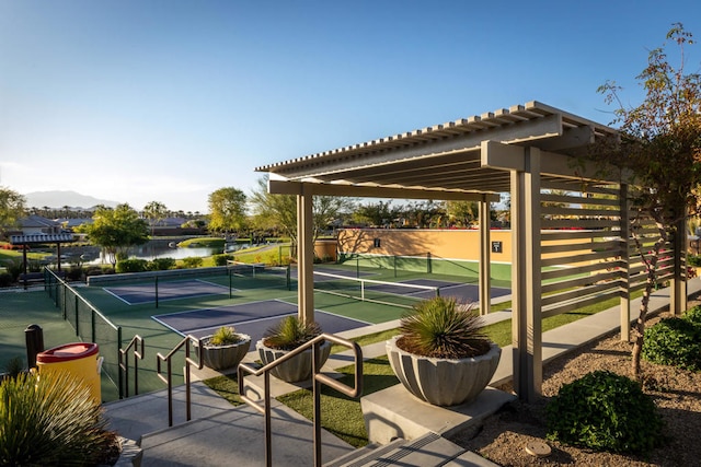 view of tennis court featuring a water view