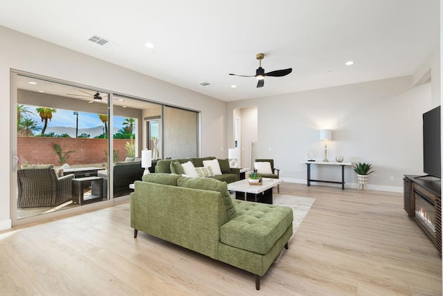 living room featuring light wood-type flooring and ceiling fan