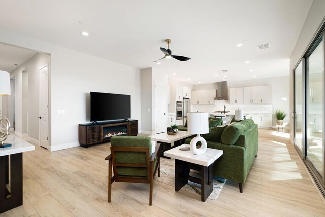 living room featuring ceiling fan and light hardwood / wood-style flooring