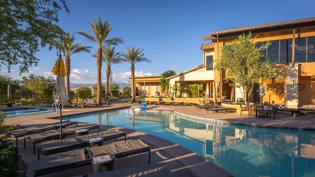 view of pool featuring a jacuzzi and a patio