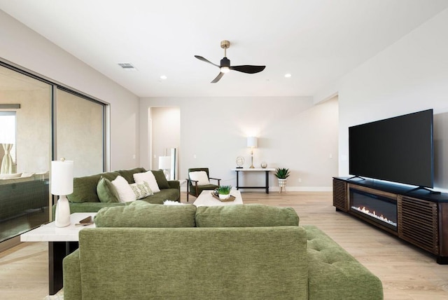 living room featuring ceiling fan and light hardwood / wood-style flooring