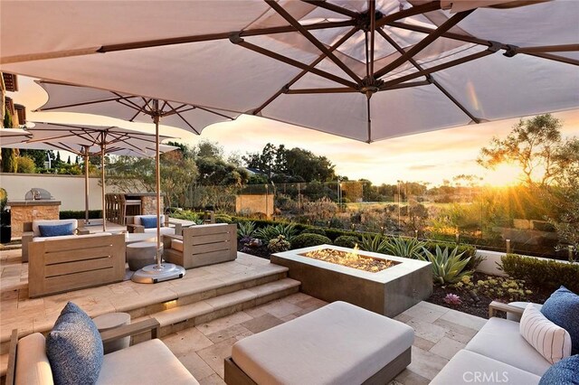 51 Monarch Beach Resort S, Dana Point, CA 92629 - patio terrace at dusk with an outdoor living space with a fire pit, a patio area, and exterior kitchen