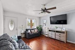 living room with ceiling fan and dark hardwood / wood-style flooring