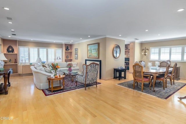 living room featuring light hardwood / wood-style floors, plenty of natural light, and ornamental molding