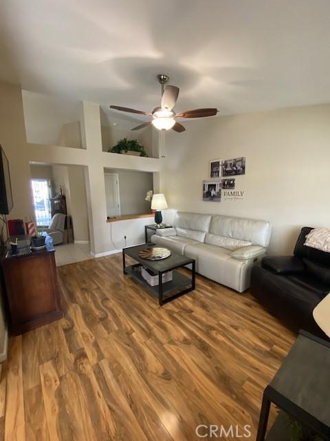 living room with vaulted ceiling, ceiling fan, and hardwood / wood-style flooring