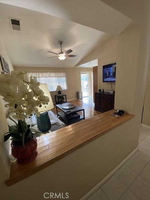 unfurnished living room featuring ceiling fan, light tile patterned flooring, and lofted ceiling