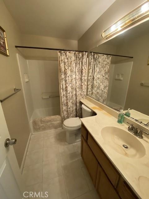 bathroom featuring a shower with curtain, tile patterned floors, vanity, and toilet