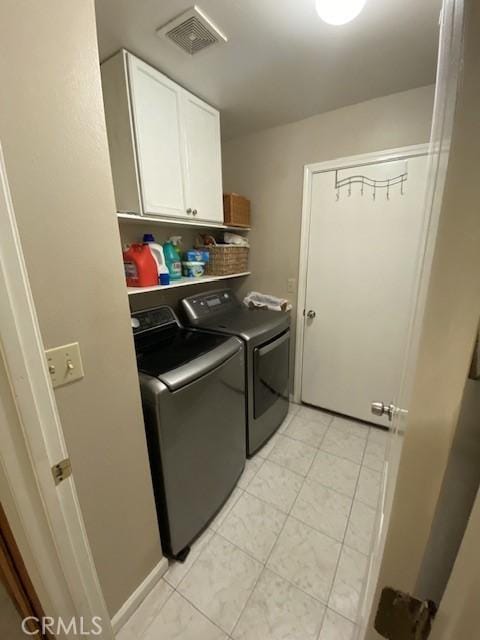 laundry room featuring cabinets and separate washer and dryer