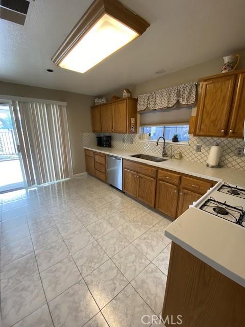 kitchen with decorative backsplash, dishwasher, and sink