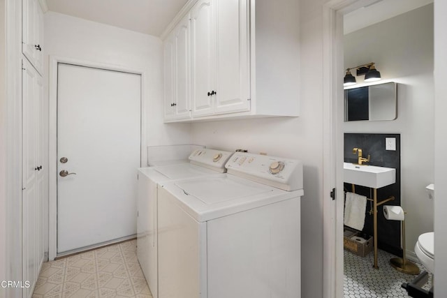 clothes washing area with washer and dryer, light tile patterned floors, and sink