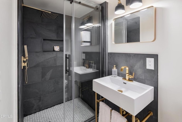 bathroom featuring decorative backsplash, a shower with door, and sink