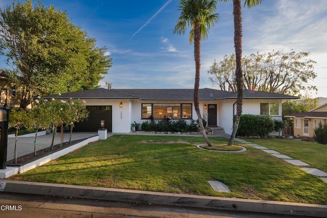 ranch-style house featuring a garage and a front yard