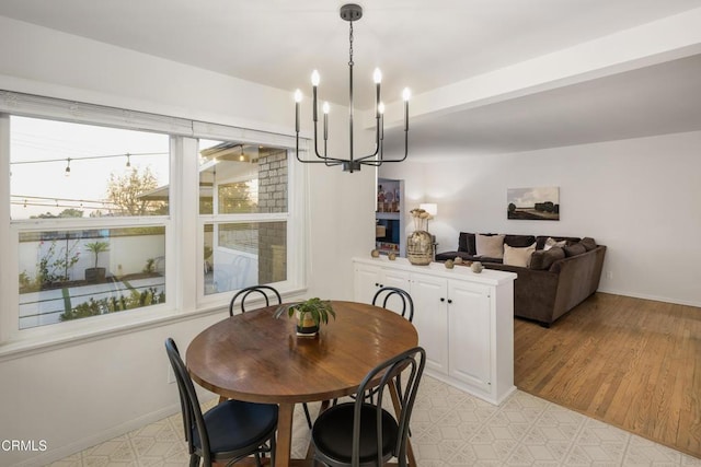 dining space with an inviting chandelier and light hardwood / wood-style flooring