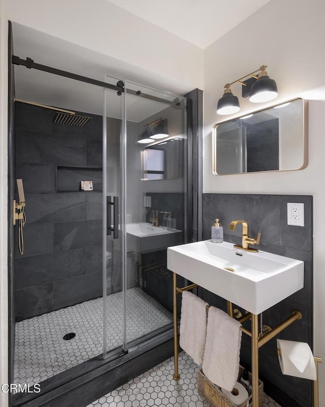 bathroom with decorative backsplash, tile patterned flooring, an enclosed shower, and sink