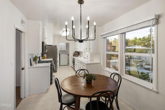 dining space featuring a notable chandelier, sink, and washer / clothes dryer