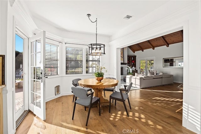 dining room featuring wood ceiling, light hardwood / wood-style floors, plenty of natural light, and lofted ceiling with beams