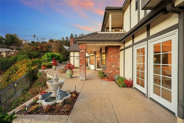 patio terrace at dusk featuring french doors