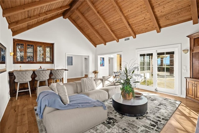 living room featuring high vaulted ceiling, indoor bar, wood ceiling, and beamed ceiling