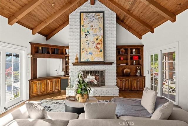 living room featuring light hardwood / wood-style floors, beam ceiling, and a fireplace