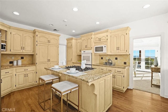 kitchen featuring a breakfast bar, backsplash, appliances with stainless steel finishes, and a kitchen island