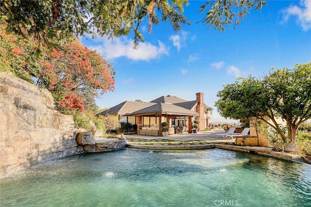 view of pool with a water view, outdoor lounge area, and a patio