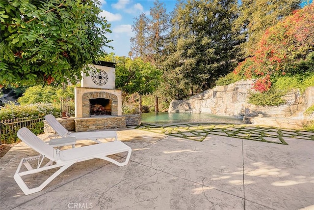 view of patio featuring an outdoor stone fireplace