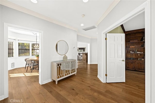 hall with hardwood / wood-style flooring and crown molding