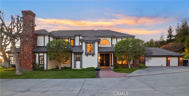 view of front of home with a garage and a lawn