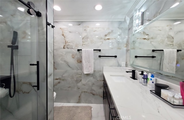 bathroom featuring vanity, a shower with shower door, and crown molding