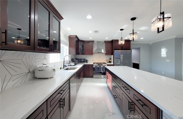 kitchen featuring sink, wall chimney exhaust hood, stainless steel appliances, tasteful backsplash, and pendant lighting