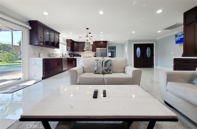 living room with ornamental molding and sink