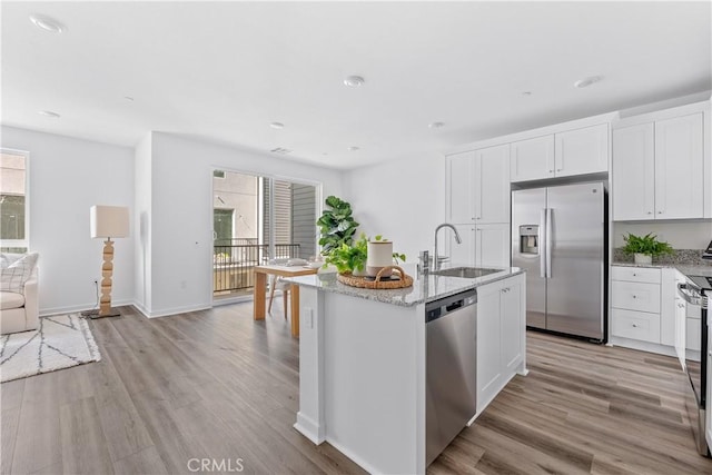 9431 N Sepulveda Blvd Unit 3, North Hills, CA 91343 - kitchen featuring stainless steel appliances, healthy amount of natural light, light stone countertops, and light wood finished floors