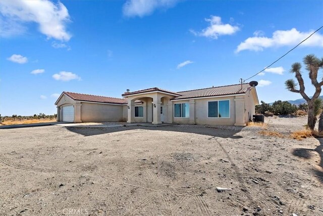 view of front of property featuring a garage and cooling unit