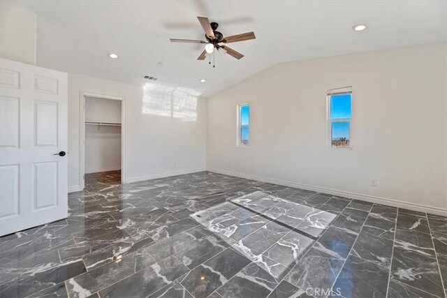 interior space featuring ceiling fan, vaulted ceiling, and a wealth of natural light