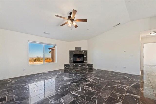 unfurnished living room with ceiling fan, lofted ceiling, and a premium fireplace