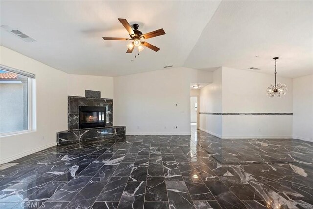 unfurnished living room with lofted ceiling, a fireplace, and ceiling fan with notable chandelier