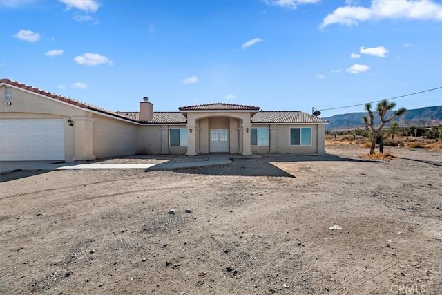 view of front of home with a mountain view and a garage