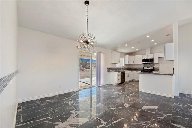 kitchen featuring pendant lighting, sink, white cabinetry, stainless steel appliances, and a chandelier