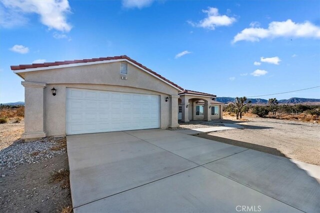 single story home featuring a mountain view and a garage