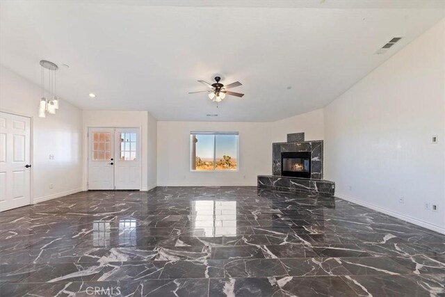 unfurnished living room featuring a high end fireplace, vaulted ceiling, and ceiling fan