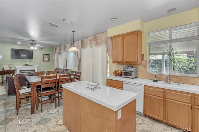 kitchen with dishwasher, hanging light fixtures, tasteful backsplash, tile counters, and a kitchen island