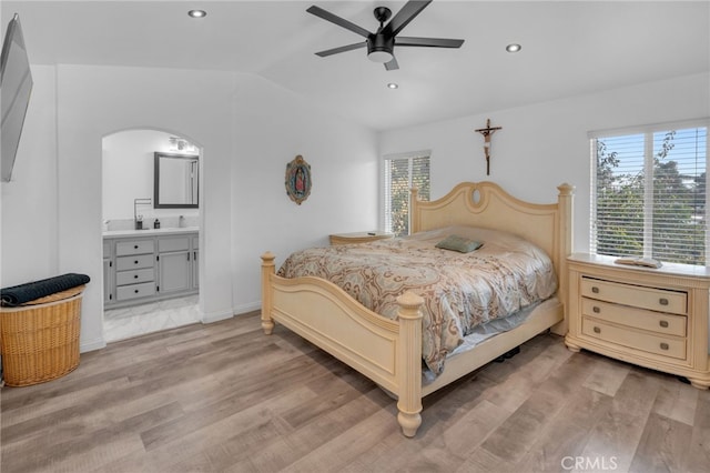 bedroom with connected bathroom, ceiling fan, sink, light hardwood / wood-style flooring, and lofted ceiling