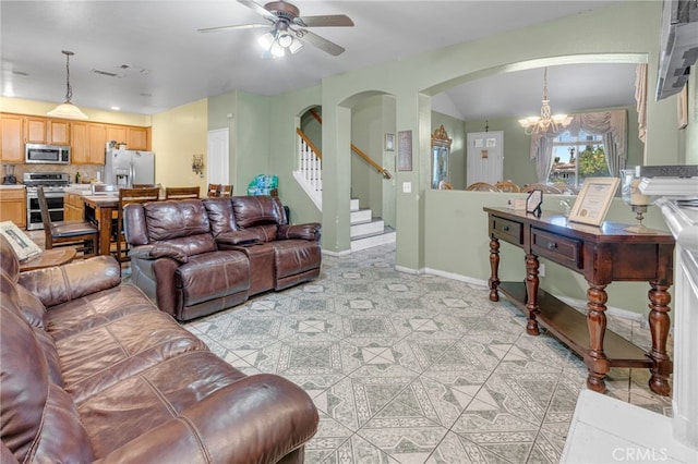 living room featuring light tile patterned flooring and ceiling fan with notable chandelier