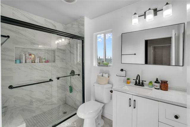 bathroom featuring vanity, toilet, and a shower with door