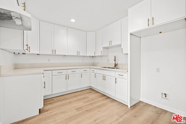 kitchen featuring white cabinetry, sink, and light hardwood / wood-style flooring