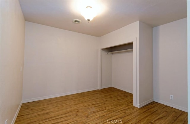 unfurnished bedroom featuring light hardwood / wood-style floors and a closet