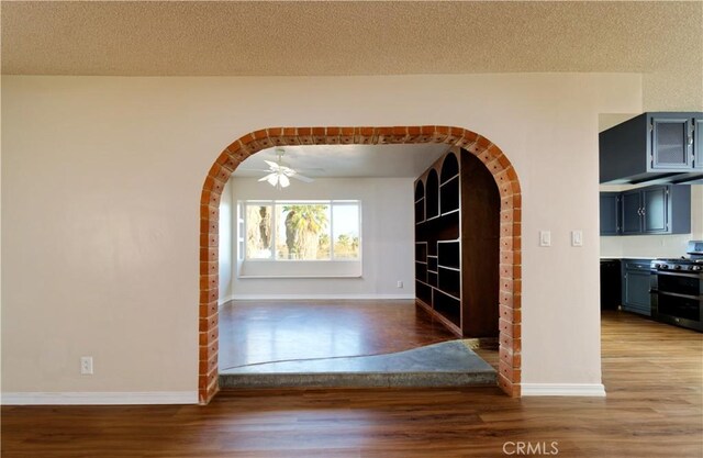 corridor featuring wood-type flooring and a textured ceiling