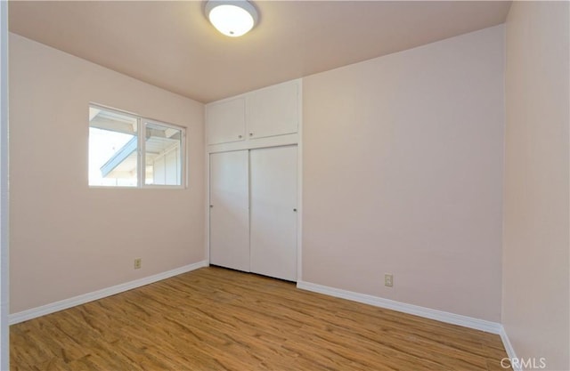 unfurnished bedroom with light hardwood / wood-style floors and a closet