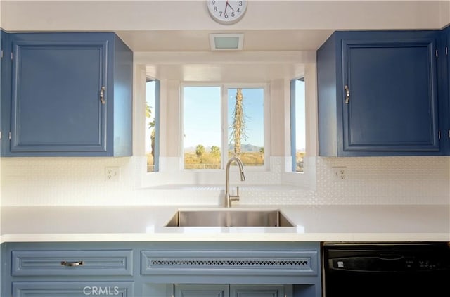 kitchen featuring blue cabinetry, tasteful backsplash, dishwasher, and sink