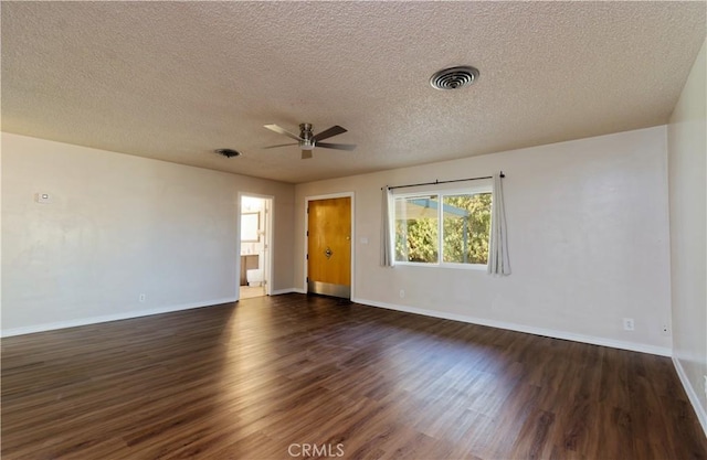 empty room with ceiling fan, dark wood-type flooring, and a textured ceiling